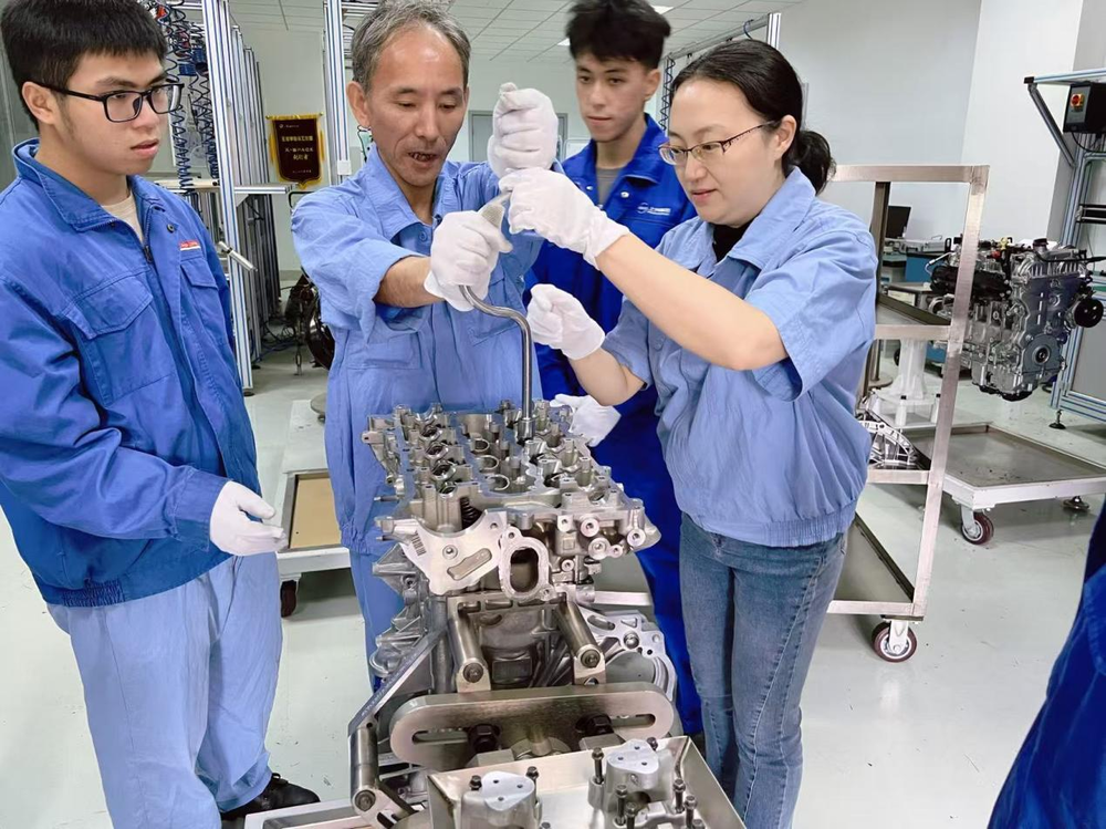 舒帆與企業導師一起指導學生拆裝發動機